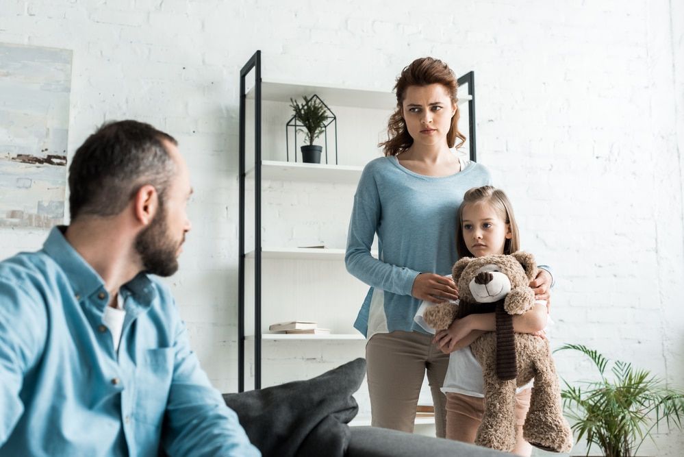 Daughter and mother looking at father