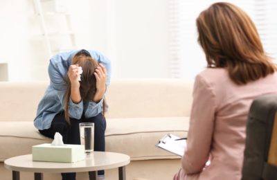 Psychotherapist working with young woman who is sad